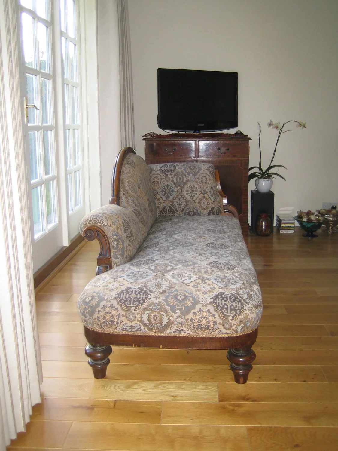 Antique chaise longue with intricate upholstery