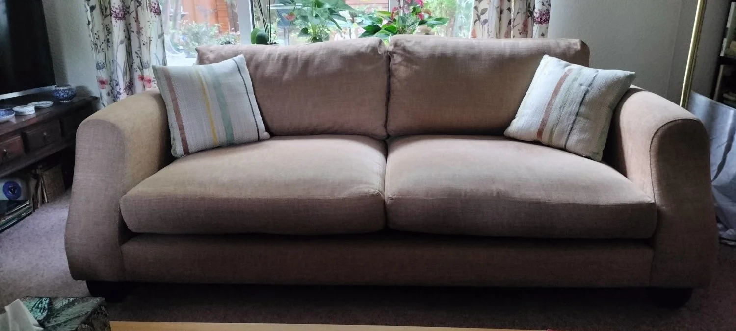 Modern two-seater sofa in warm taupe woven fabric with scatter cushions