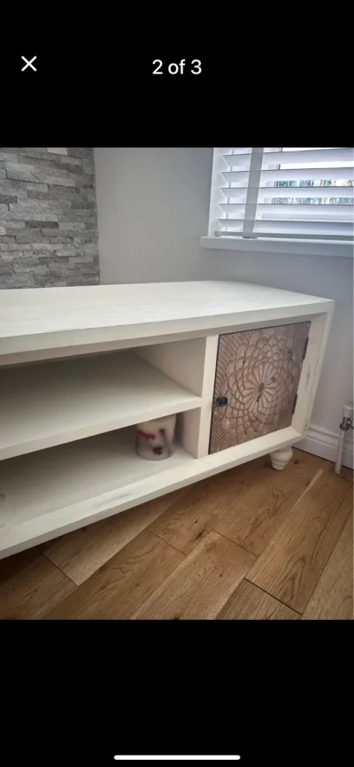Cream TV media console with carved floral sliding cupboard doors — image 3