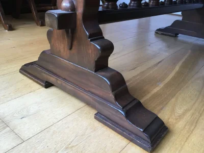 Vintage dark wood trestle dining table with 6 red leather backed chairs — image 3