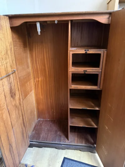 Vintage dark wood wardrobe with carved doors, hanging rail and shelves — image 3