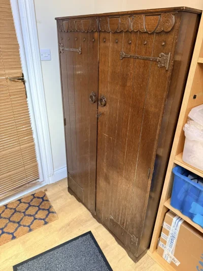 Vintage dark wood wardrobe with carved doors, hanging rail and shelves — image 2