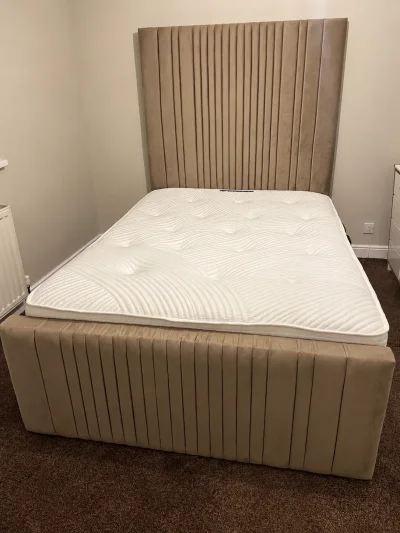 Taupe upholstered bed frame with tall fluted headboard and footboard