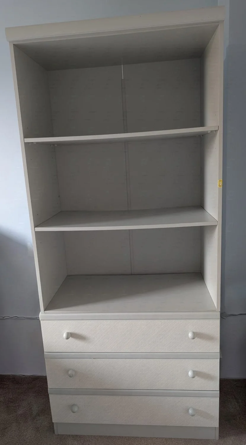 Tall white bookcase with three drawers and open shelving